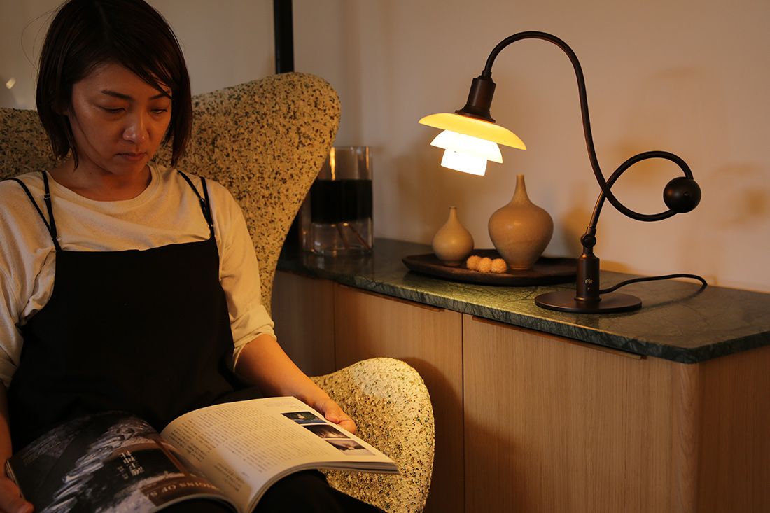 PH 1/1 Piano Table Lampの灯りで読書する女性