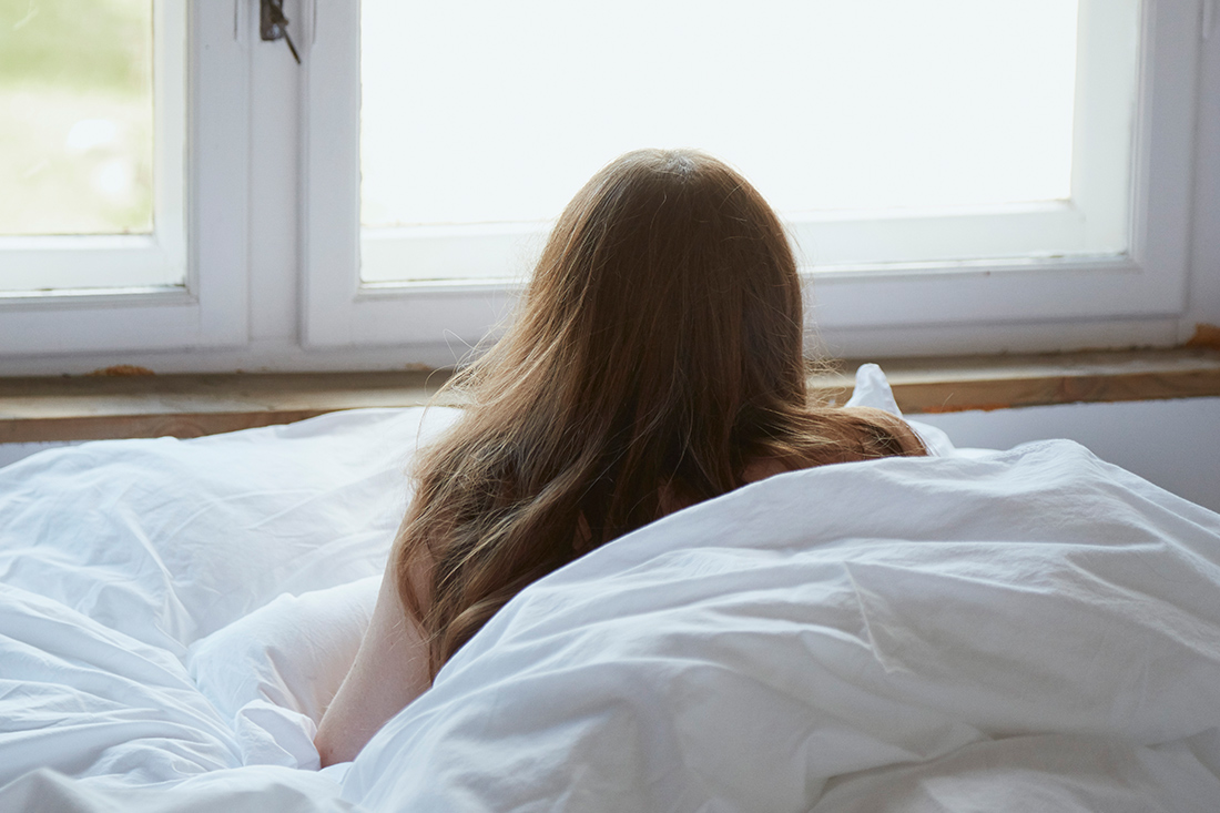 ベッドで横になり外を眺めている女の子