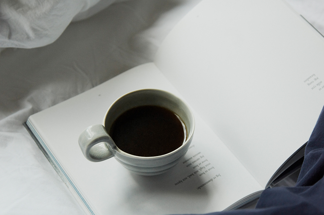 ベッド上のにあるコーヒーカップ