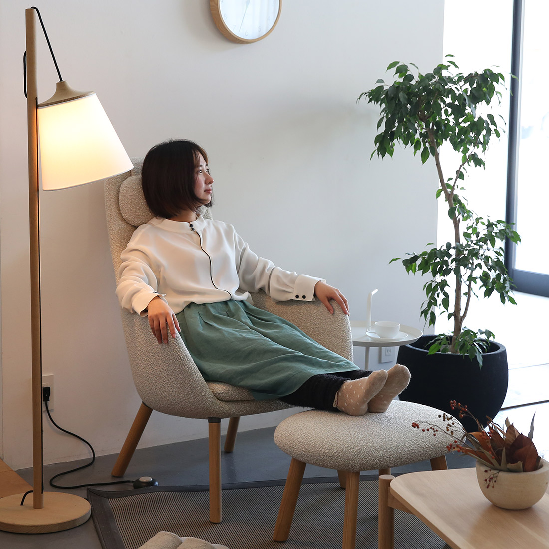 ハル ラウンジチェアとオットマンに座る女性